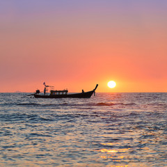 Traditional thai longtail boat against sunset above ocean, Thail