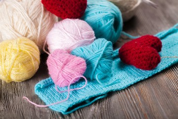 Fototapeta na wymiar Crocheting. Crochet pink hearts and yarn on wooden background