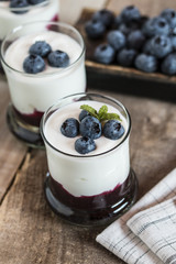 Yogurt with fresh blueberries and blueberries jam, in glass bowl