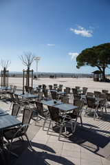 Beach view of a coffee terrace with tables and chairs