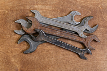 Rusty old spanners on wooden background