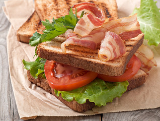 hot big sandwich, toast and bacon with tomato, parsley, lettuce