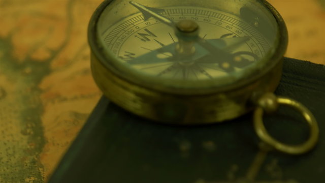 A compass on top of the edge of the bible
