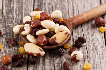 Mixed nuts on a wooden spoon.