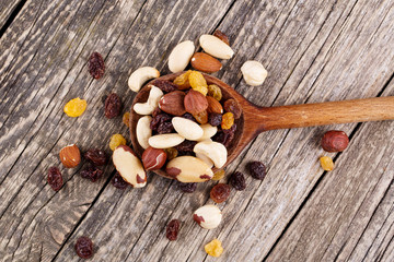 Mixed nuts on a wooden spoon.