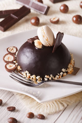 chocolate cake with nuts, topped with macaroon vertical