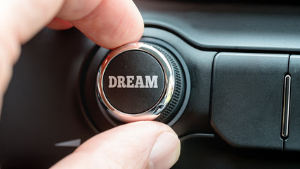 Man turning on a dream button with the word - Dream
