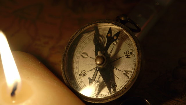 The compas beside the lighted candle