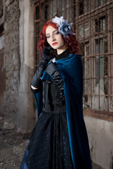 Gothic redhead woman walking with candle