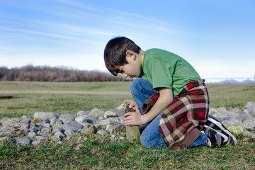 Boy plays wih rocks.