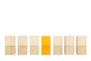 wooden blocks standing in line with orange one in the centre