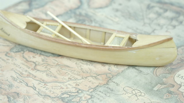 A small wooden boat on top of the map