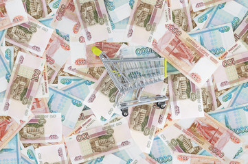 Grocery cart on background of Russian rubles..