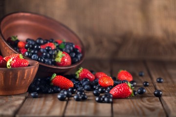 Assorted. Mix of fresh berries in a basket on rustic wooden