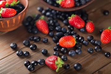 Assorted. Mix of fresh berries in a basket on rustic wooden