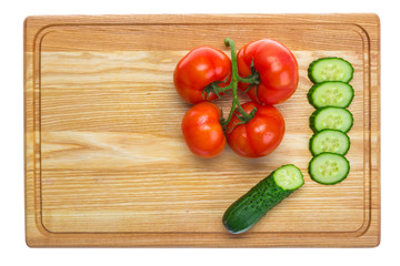 fresh tomatoes and sliced cucumber on a wooden cutting board