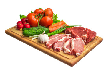 Fresh raw meat and vegetables on a cutting board