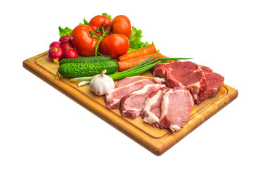 Fresh raw meat and vegetables on a cutting board