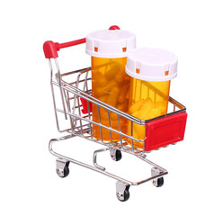 Pill bottle in shopping cart isolated on white background