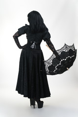 Gothic vampire in black dress with umbrella back
