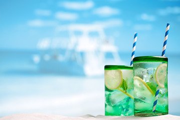 cocktail with ice, rum, lemon and mint   in a  glass  on beach