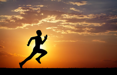 Fototapeta na wymiar Silhouette of running man against the colorful sky.