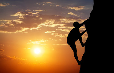 Rock climber at sunset background. Sport and active life