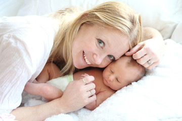 Obraz na płótnie Canvas Happy Young Mother Snuggling her Newborn Baby Girl