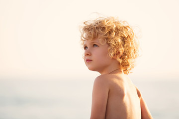 Adorable happy little girl on beach vacation, close up portrait