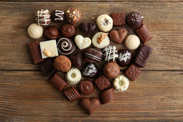 Delicious chocolate candies on wooden background