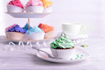 Delicious cupcakes on plate on table close-up
