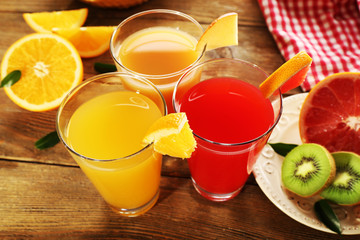 Fresh juices with fruits on wooden table