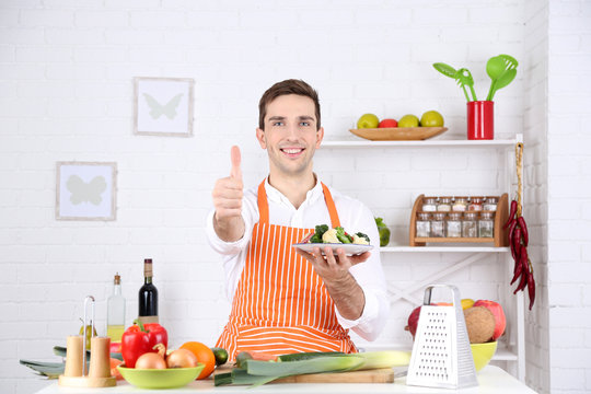 Man at table with different products and utensil in kitchen