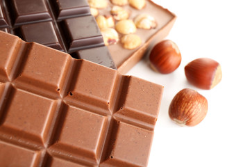 Black and milk chocolate bars with hazelnuts close up