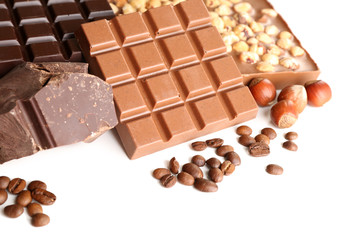 Chocolate bars with hazelnuts and coffee beans close up