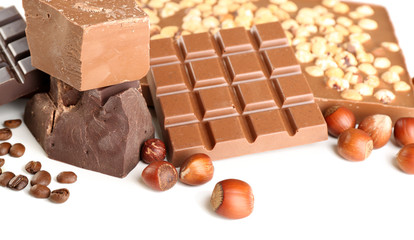 Chocolate bars with hazelnuts and coffee beans close up