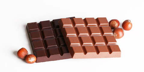 Milk and black chocolate bars with hazelnuts isolated on white