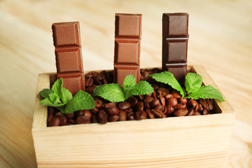 Still life with set of chocolate in wooden box of coffee grains