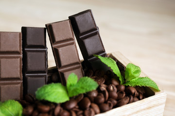Still life with set of chocolate in wooden box of coffee grains