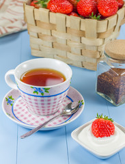 A cup of redbush tea witha strawberry-yogurt dessert