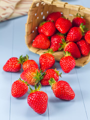 Basket with strawberries spilling on a table