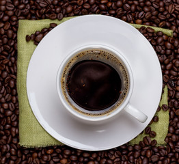 Coffee cup and saucer and coffee beans. Top view.