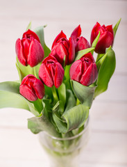 Red tulips on an antique wooden background