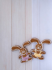 Two Easter Bunny cookies on the white wooden background