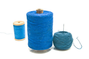 ball of yarn and spools of thread on white