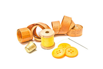 spool of yellow thread, thimble and yellow buttons