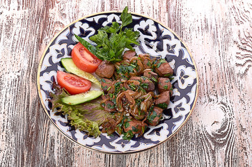 Fried meat with onion in a frying pan