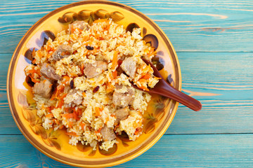 traditional oriental pilaf, rice with meat and carrot on blue