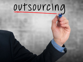 Businessman hand writing Outsourcing. Business concept.