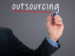 Businessman hand writing Outsourcing. Business concept.